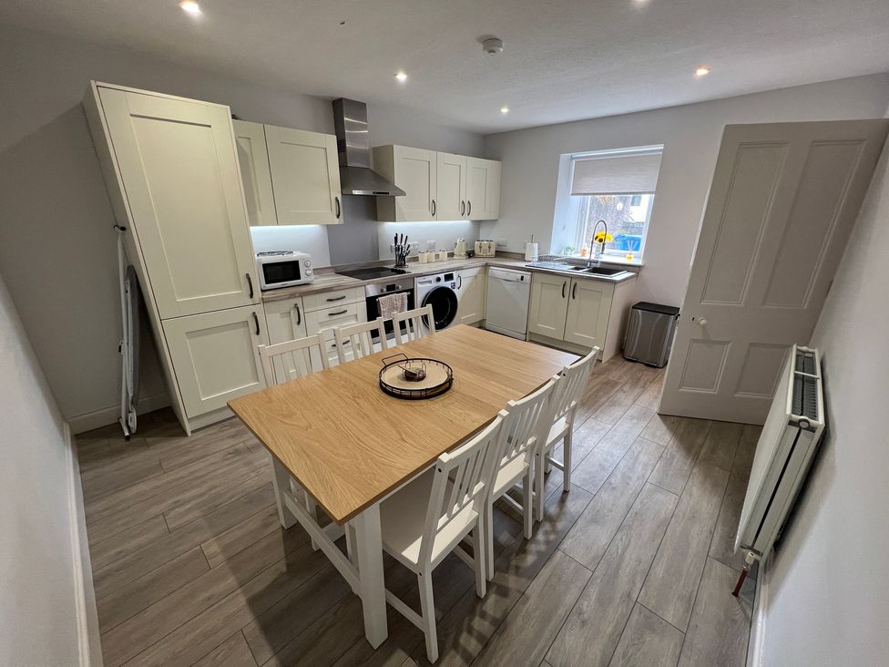 A kitchen with a dining table and chairs and appliances at 1 Links Place Nairn