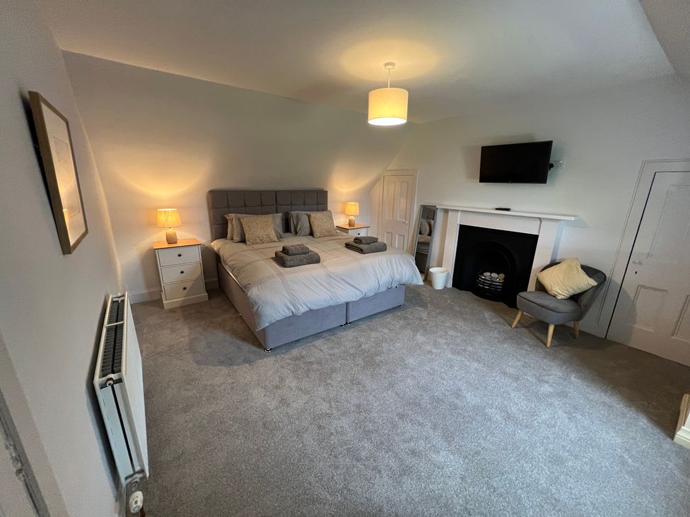 A bedroom with a bed and television at 1 Links Place Nairn