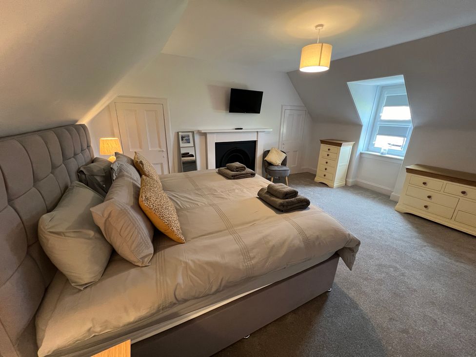 A bedroom with a bed and television at 1 Links Place Nairn
