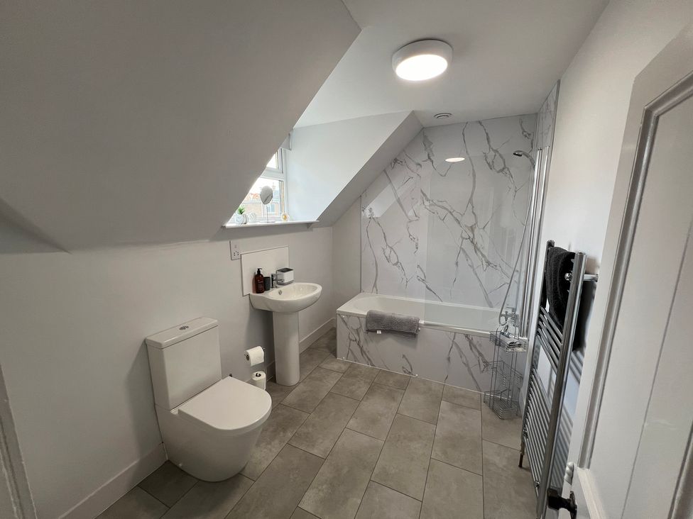 A bathroom with a toilet, sink, and bathtub at 1 Links Place Nairn