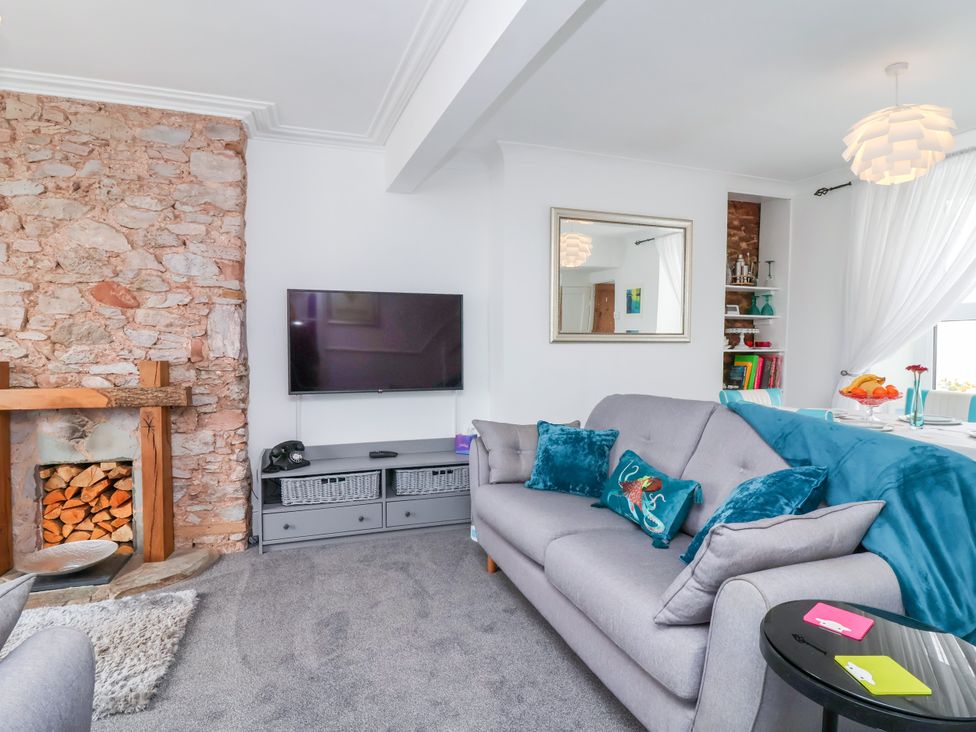 A living room with a television and sofa at 45 North View in Brixham
