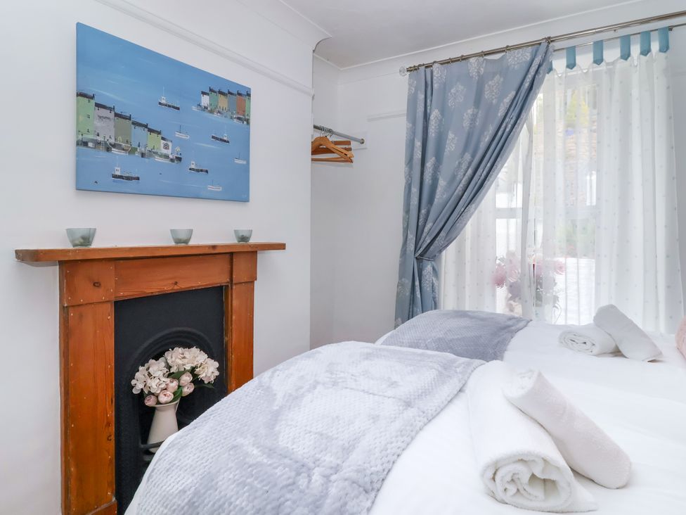 A bedroom with two beds and a painting at 45 North View in Brixham