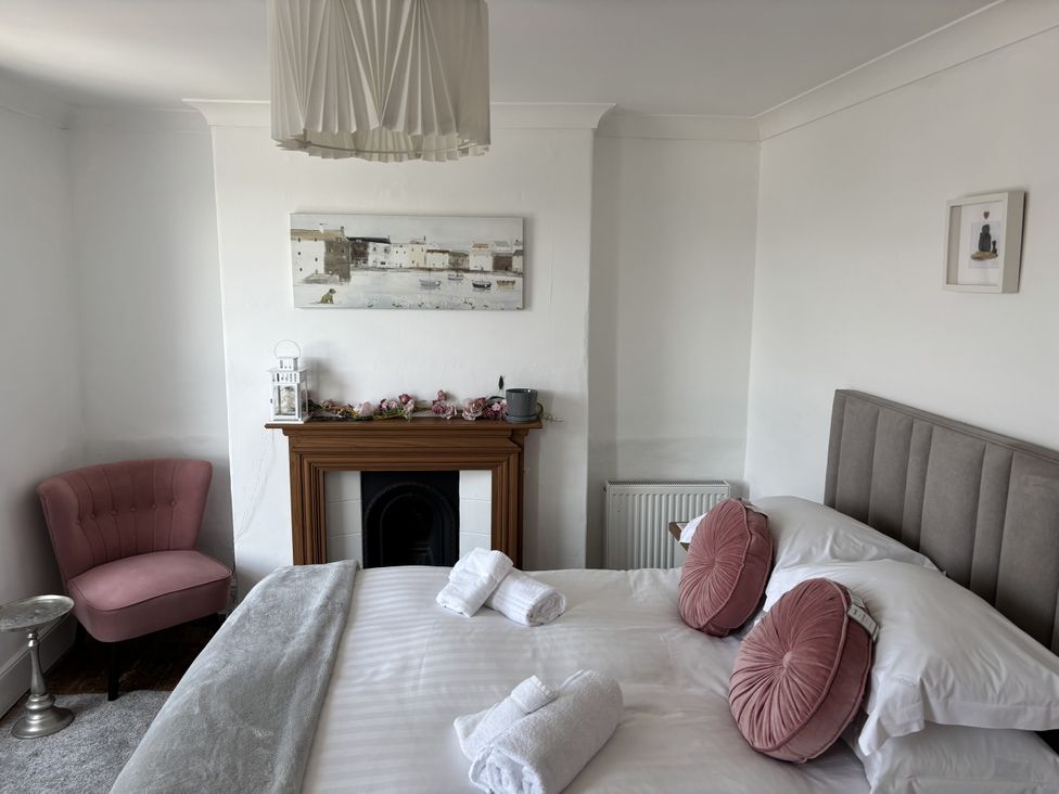 A bedroom with a bed, chair, and artwork at 45 North View in Brixham