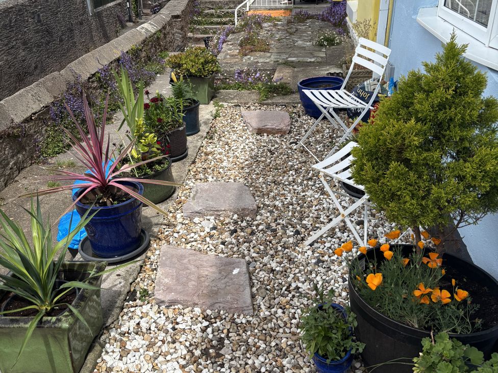 A garden path with plants and chairs at 45 North View Brixham