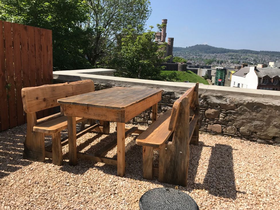 A table and benches in an outdoor area at View Cottage in Inverness