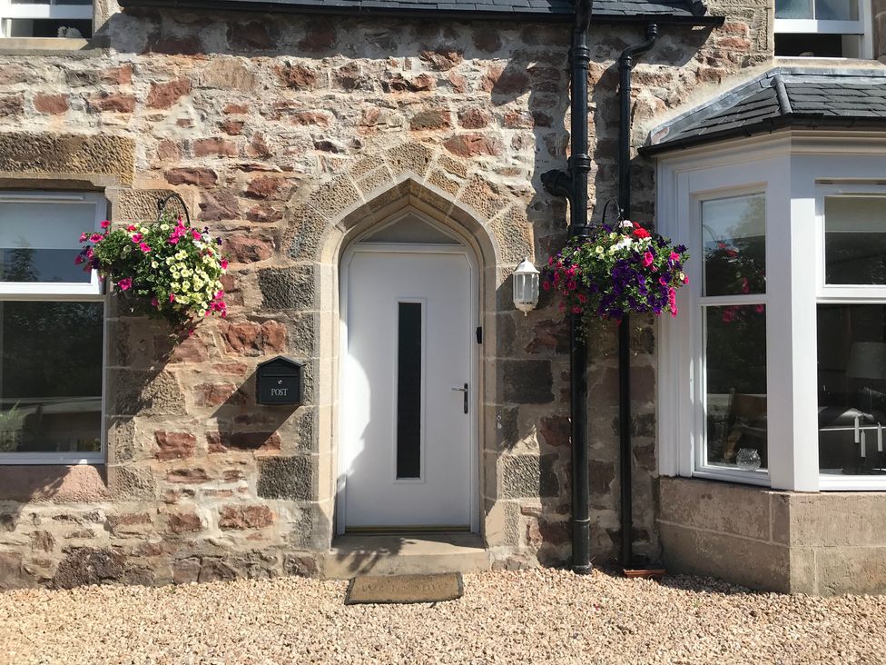A front entrance with a door, windows and planters at View Cottage in Inverness
