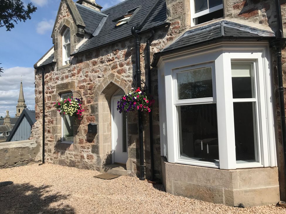 An exterior view of a stone house with flower pots at View Cottage in Inverness