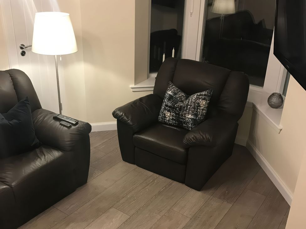 A living room with an armchair and floor lamp at View Cottage in Inverness