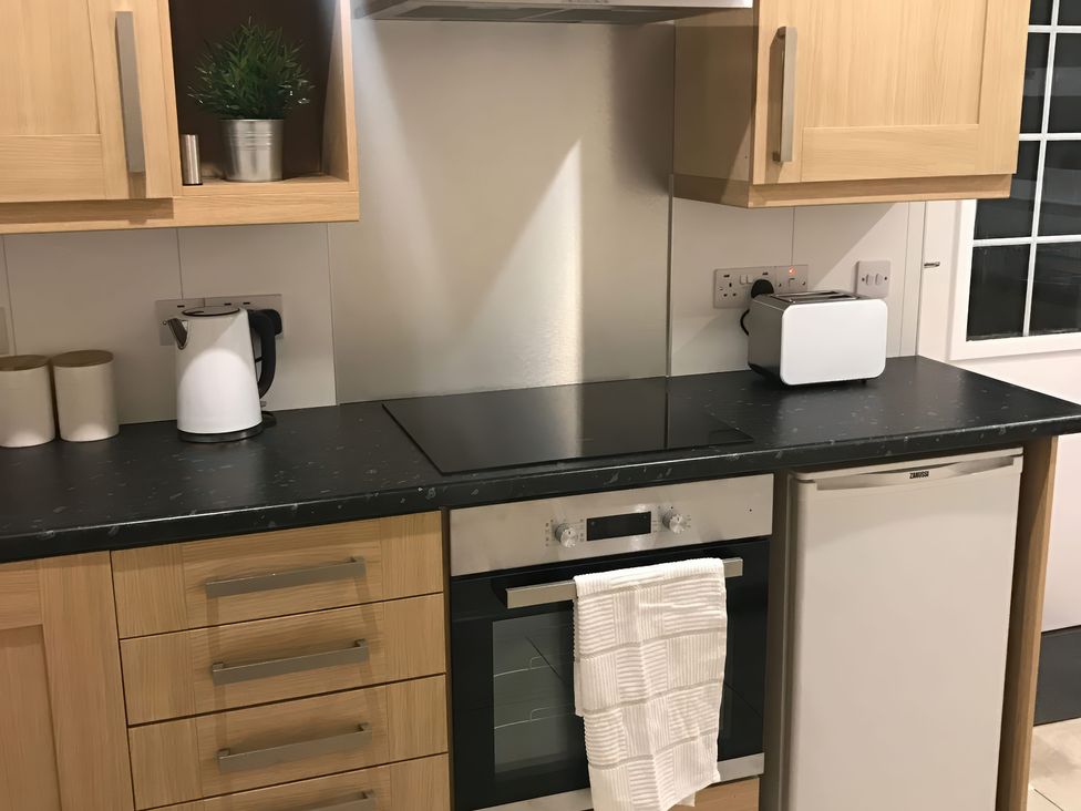 A kitchen with a kettle, toaster, and oven at View Cottage in Inverness