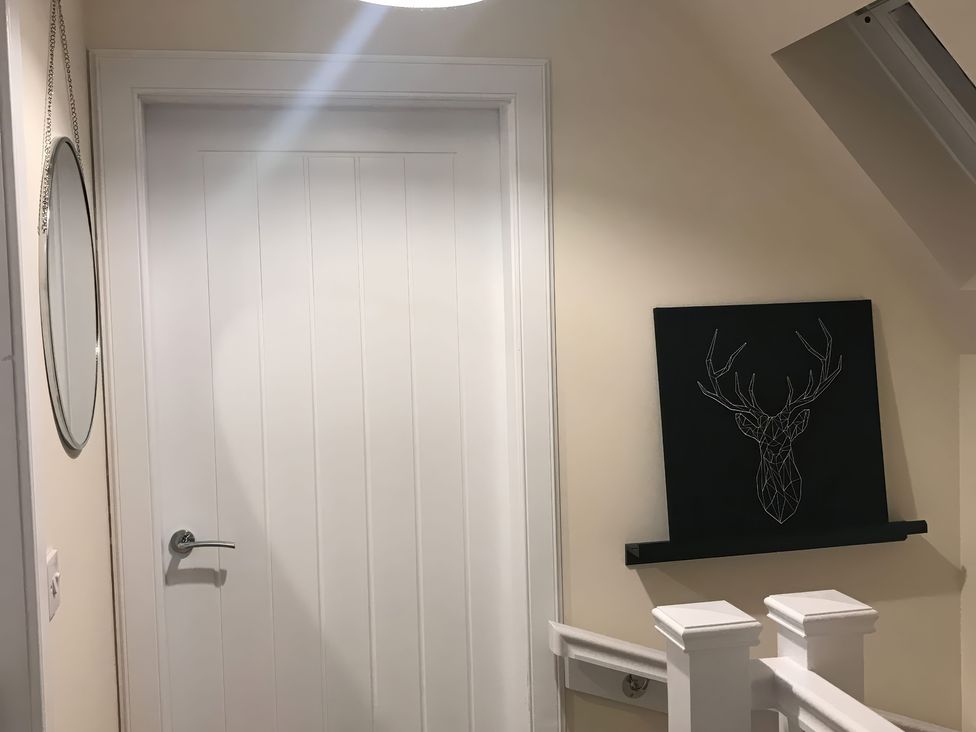 A hallway with a door and mirror at View Cottage in Inverness