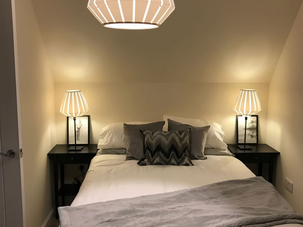 A bedroom with a bed and bedside tables at View Cottage in Inverness