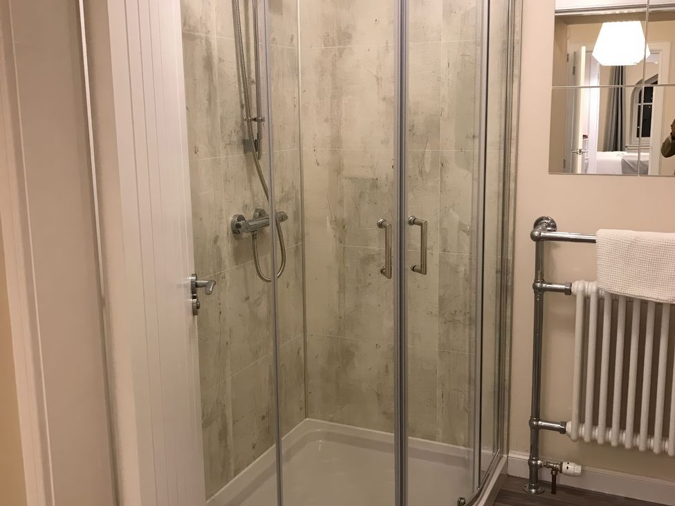 A bathroom with a shower enclosure and towel rack at View Cottage in Inverness