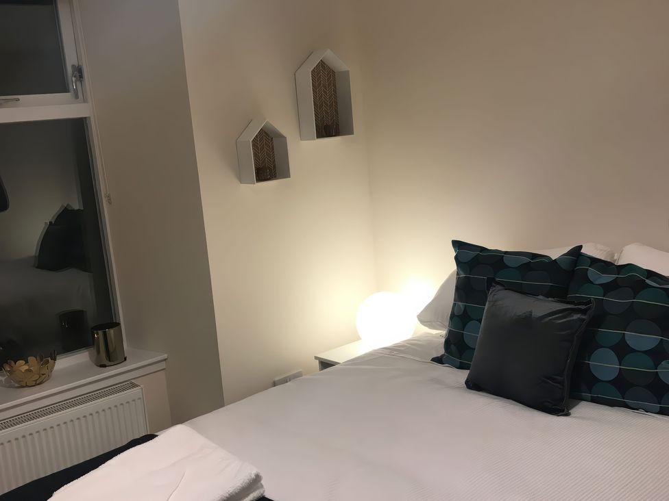 A bedroom with a bed and decorative pillows at View Cottage in Inverness