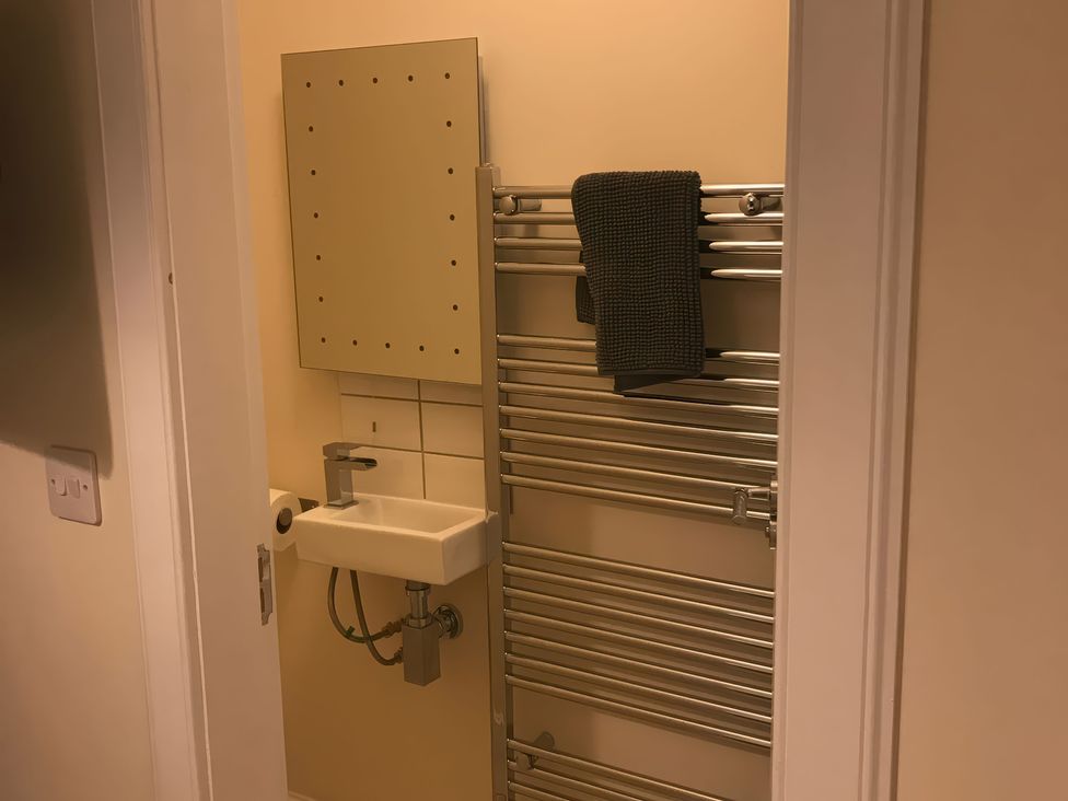 A bathroom with a sink, towel warmer and mirror at View Cottage in Inverness