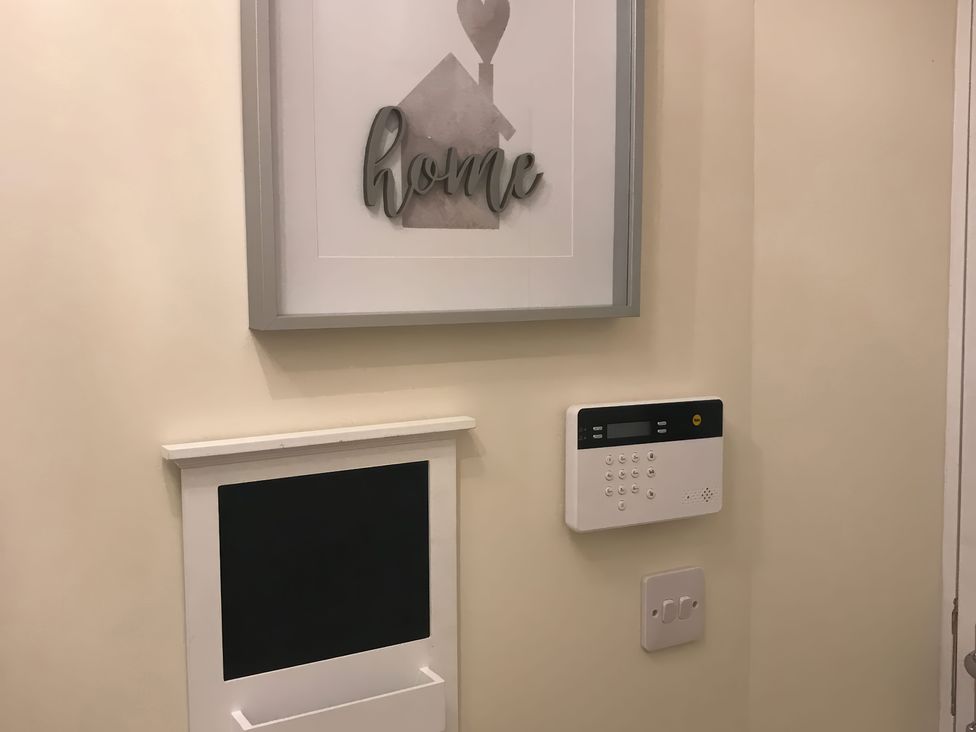 A hallway with a framed artwork and an intercom system at View Cottage in Inverness