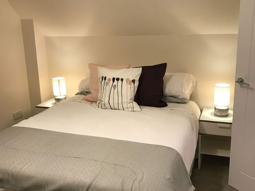A bedroom with a bed and nightstands at View Cottage in Inverness