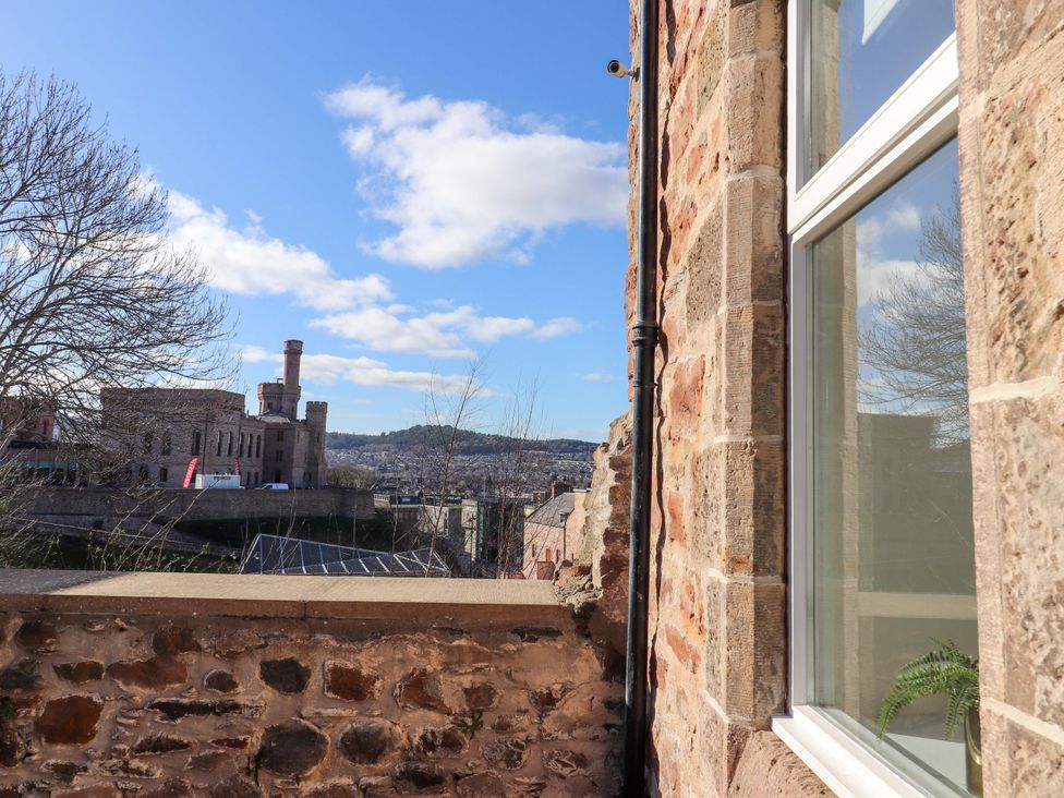 A view from a window showing buildings and trees at View Cottage in Inverness