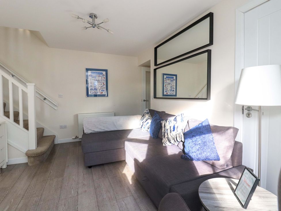 A living room with a sofa and mirror at View Cottage in Inverness