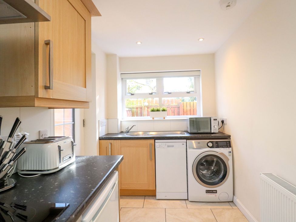 A kitchen with a washing machine and microwave at View Cottage in Inverness