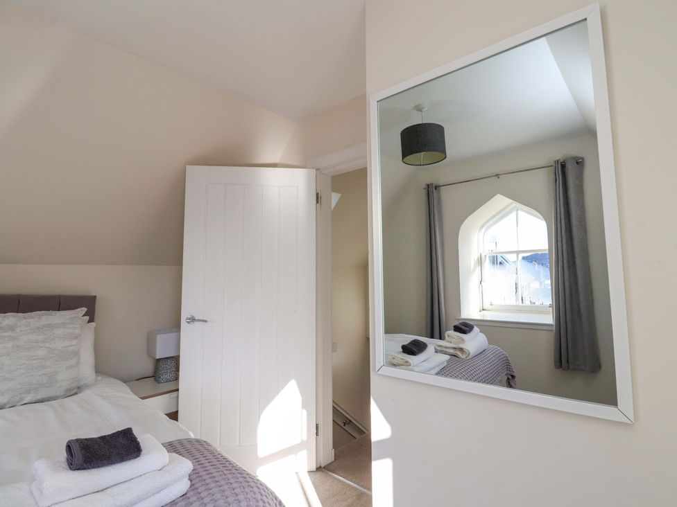 A bedroom with a bed and a mirror at View Cottage in Inverness