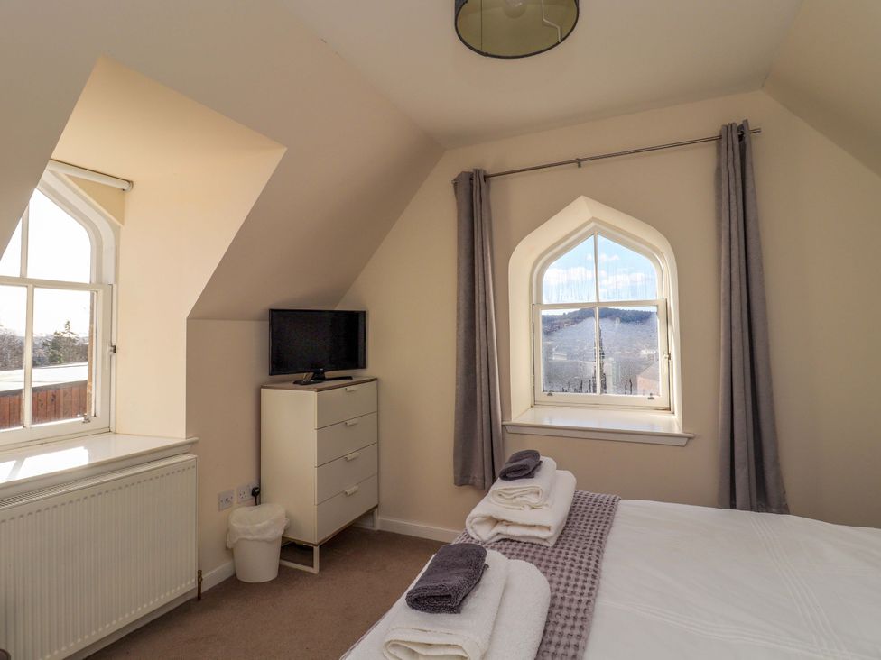 A bedroom with a bed and television at View Cottage in Inverness
