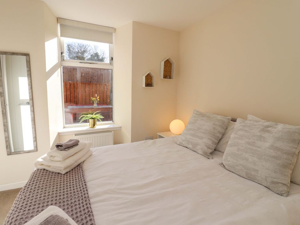 A bedroom with a bed and a mirror at View Cottage Inverness