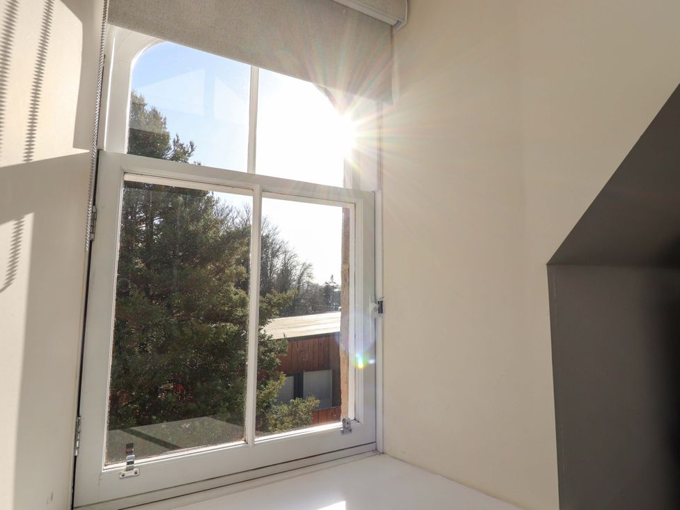 A window with sunlight and trees visible outside at View Cottage in Inverness