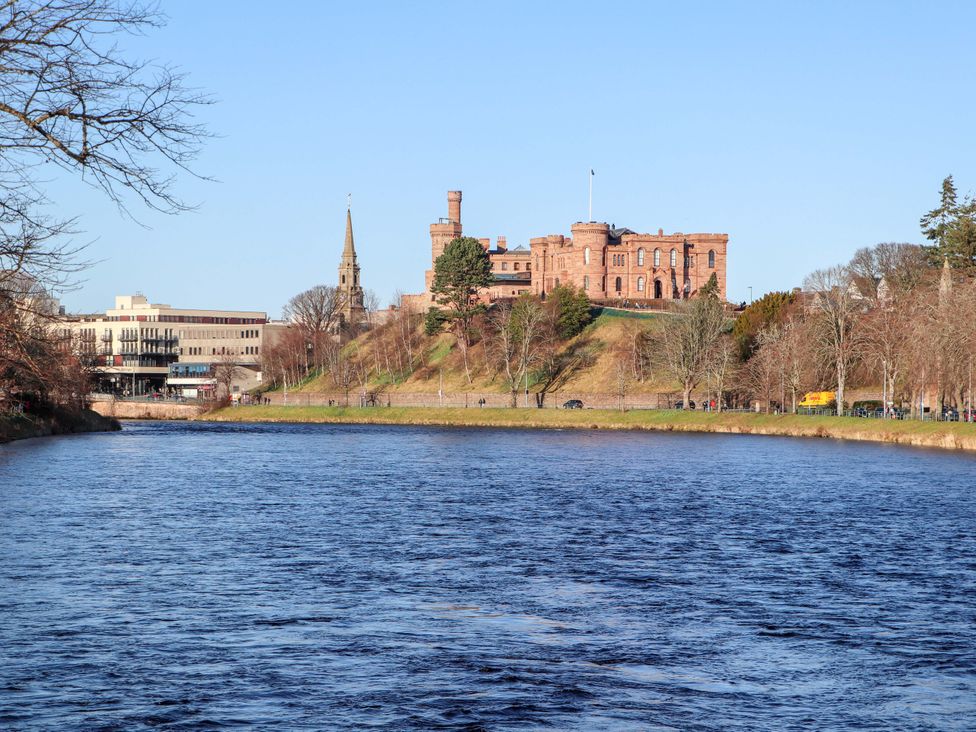 A view of a river with a castle on a hill at View Cottage Inverness