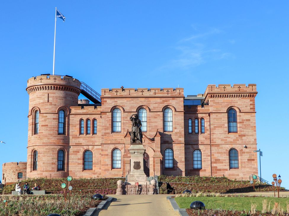A castle with a statue in front and a flag at View Cottage Inverness