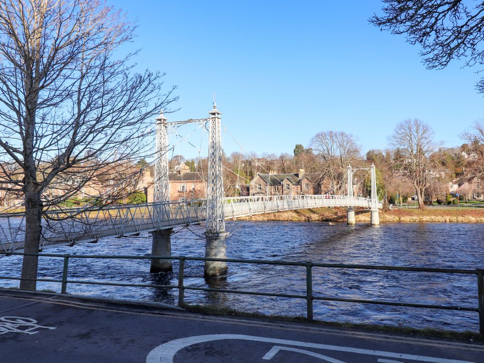 A suspension bridge over a river at View Cottage in Inverness
