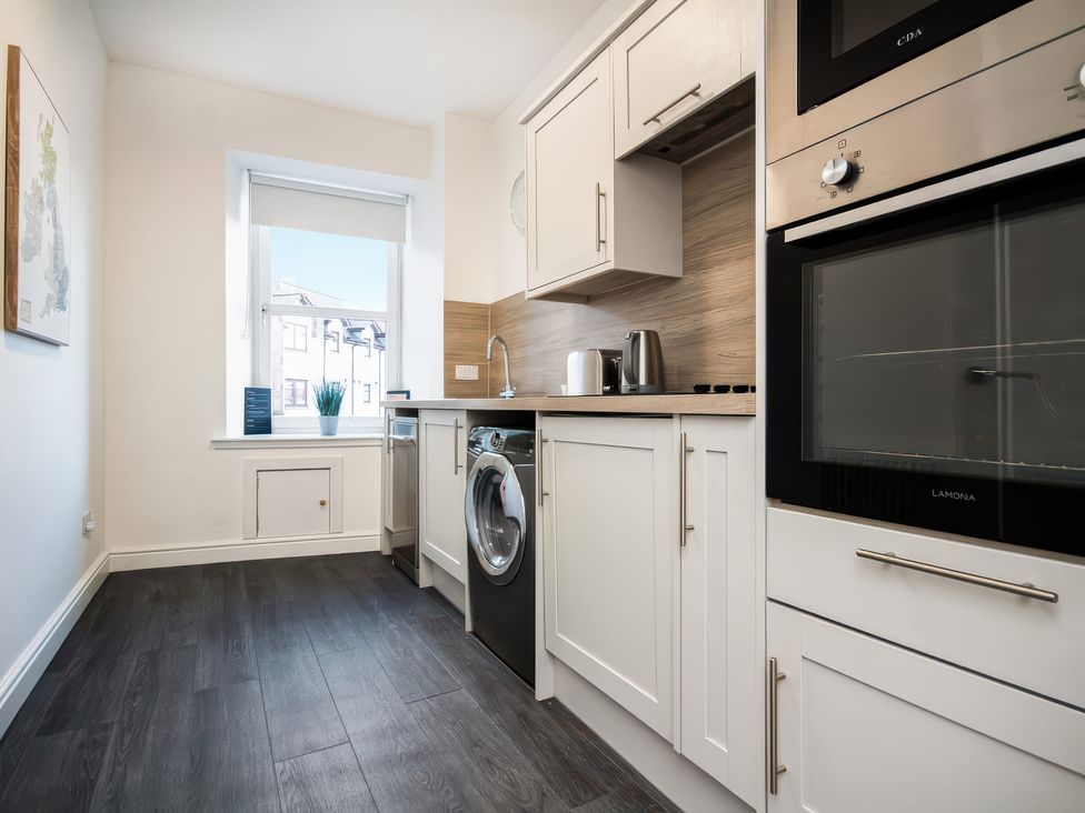 A kitchen featuring a washing machine and an oven at 4 Lower Kessock Street in Inverness