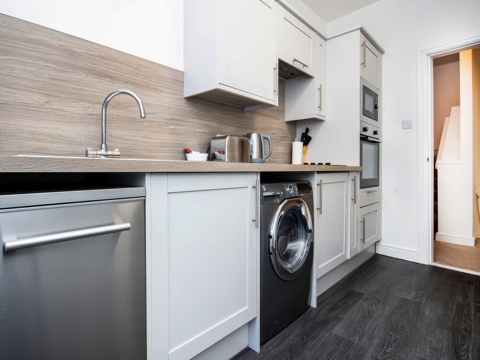 A kitchen with appliances including a washing machine and oven at 4 Lower Kessock Street Inverness