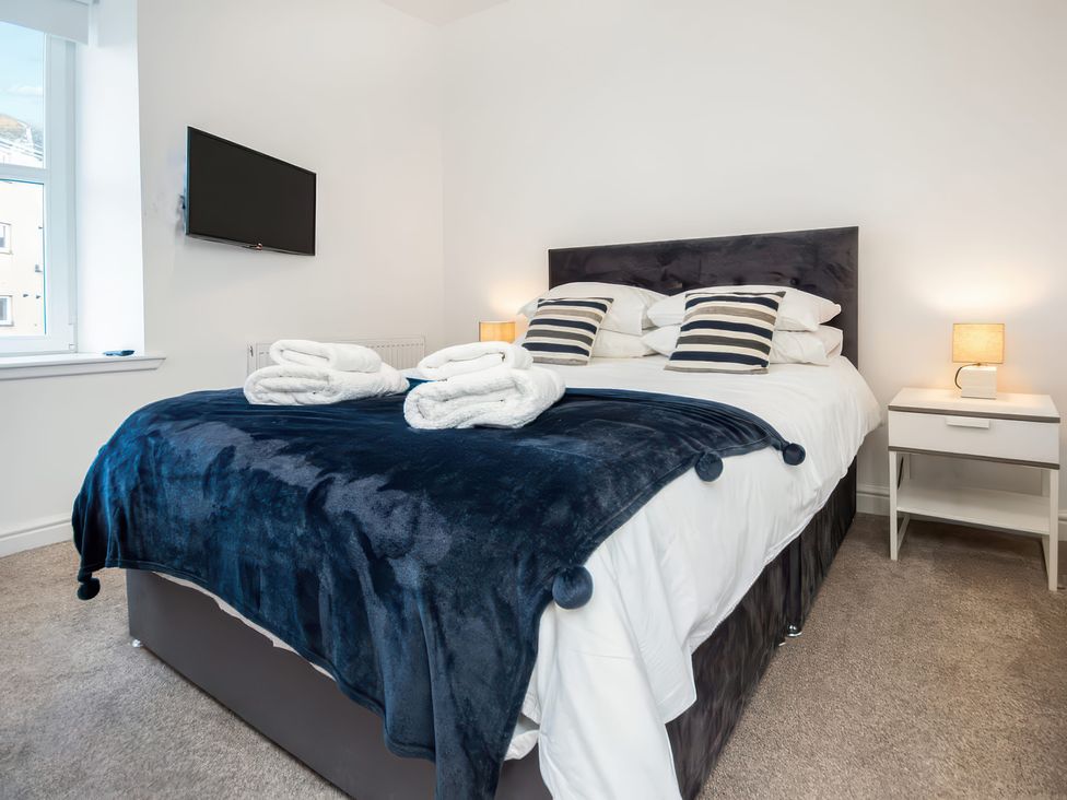 A bedroom with a bed and nightstand at 4 Lower Kessock Street in Inverness