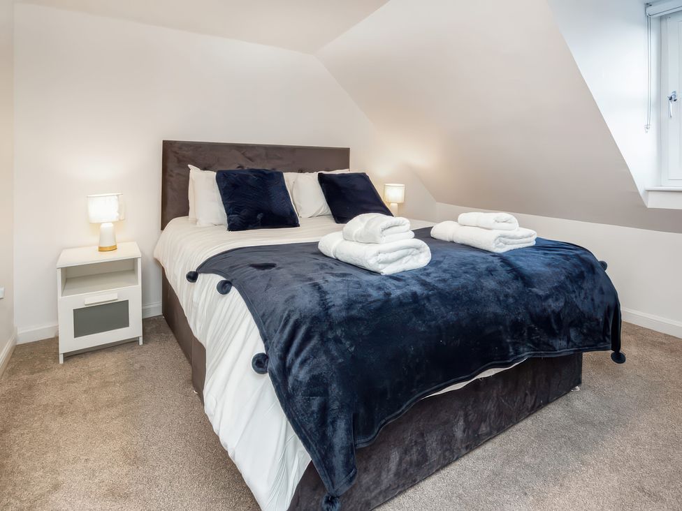 A bedroom with a bed and nightstand at 4 Lower Kessock Street in Inverness