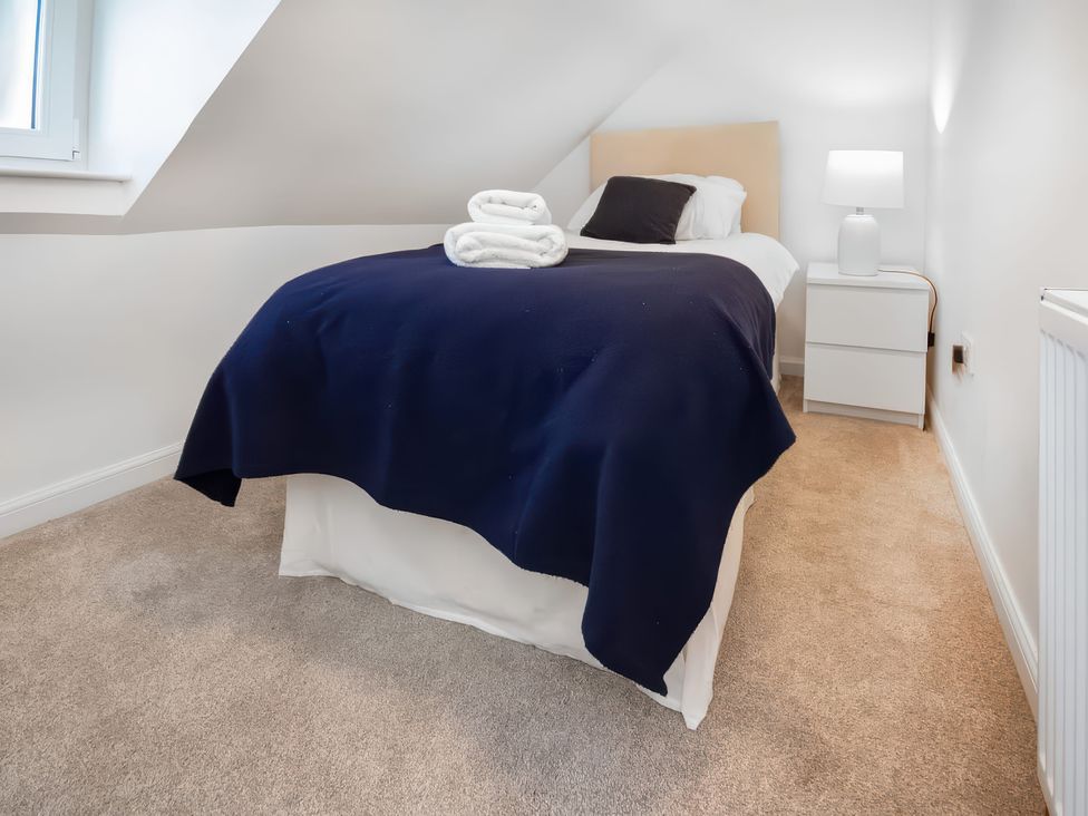 A bedroom with a bed and nightstand at 4 Lower Kessock Street Inverness