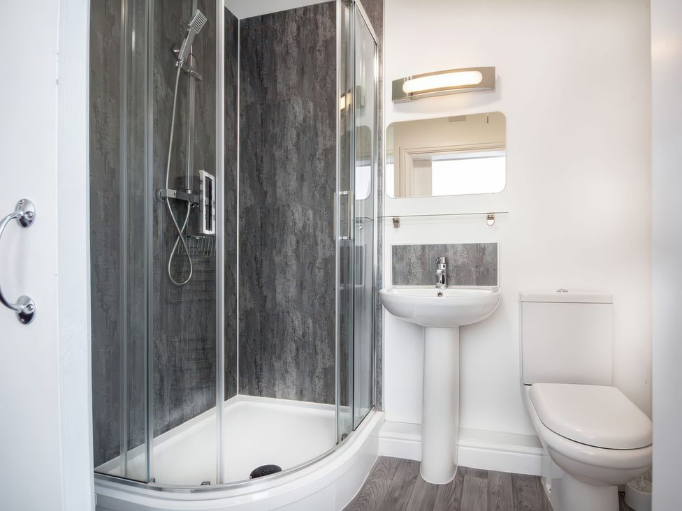 A bathroom with a shower, toilet, and sink at 4 Lower Kessock Street in Inverness
