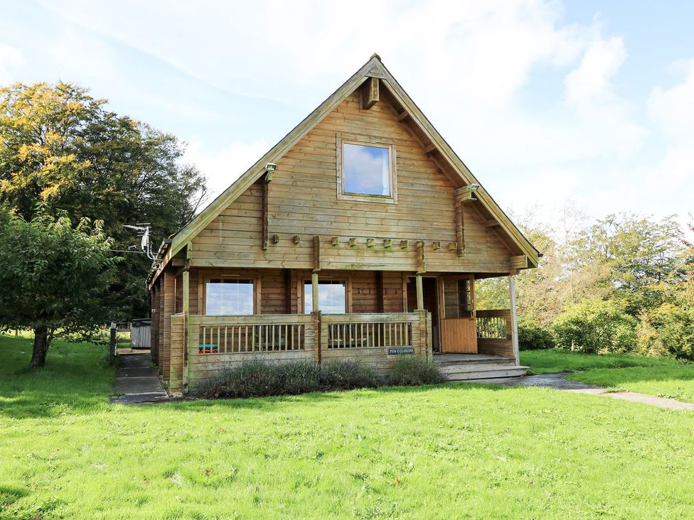 A wooden house with a porch and grass area at Pen Y Clawdd near Beggar's Bush Presteigne