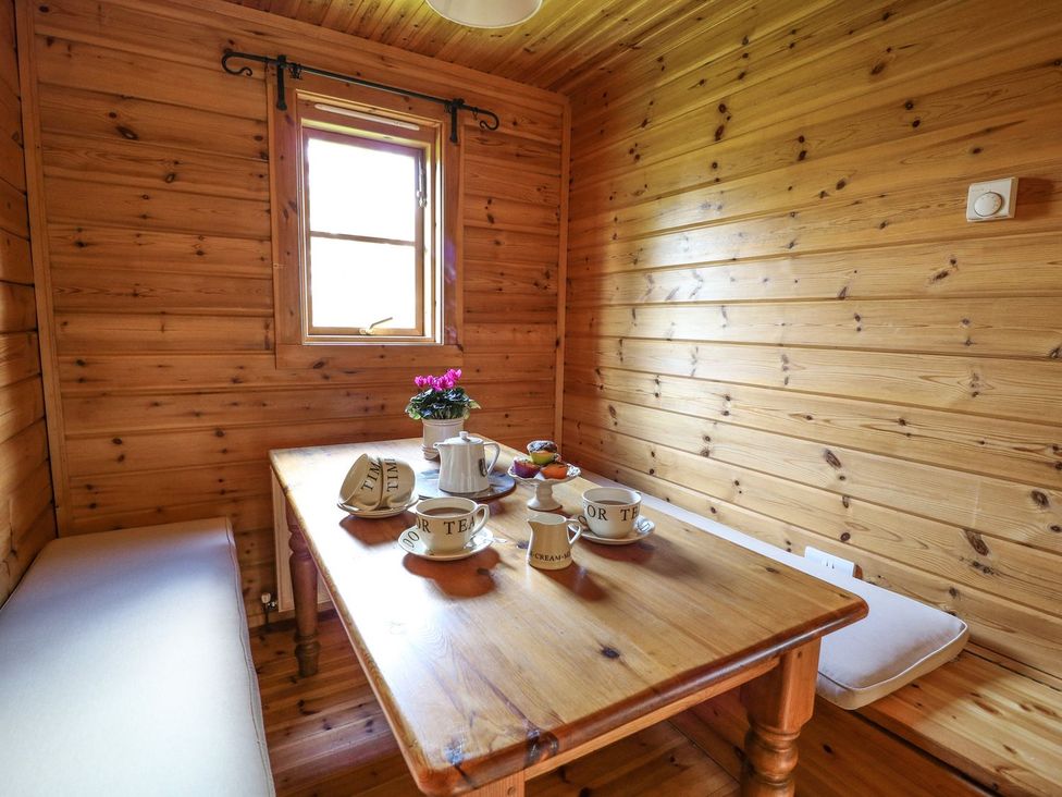 A snug with a wooden table and tea set at Pen Y Clawdd near Beggar's Bush near Presteigne