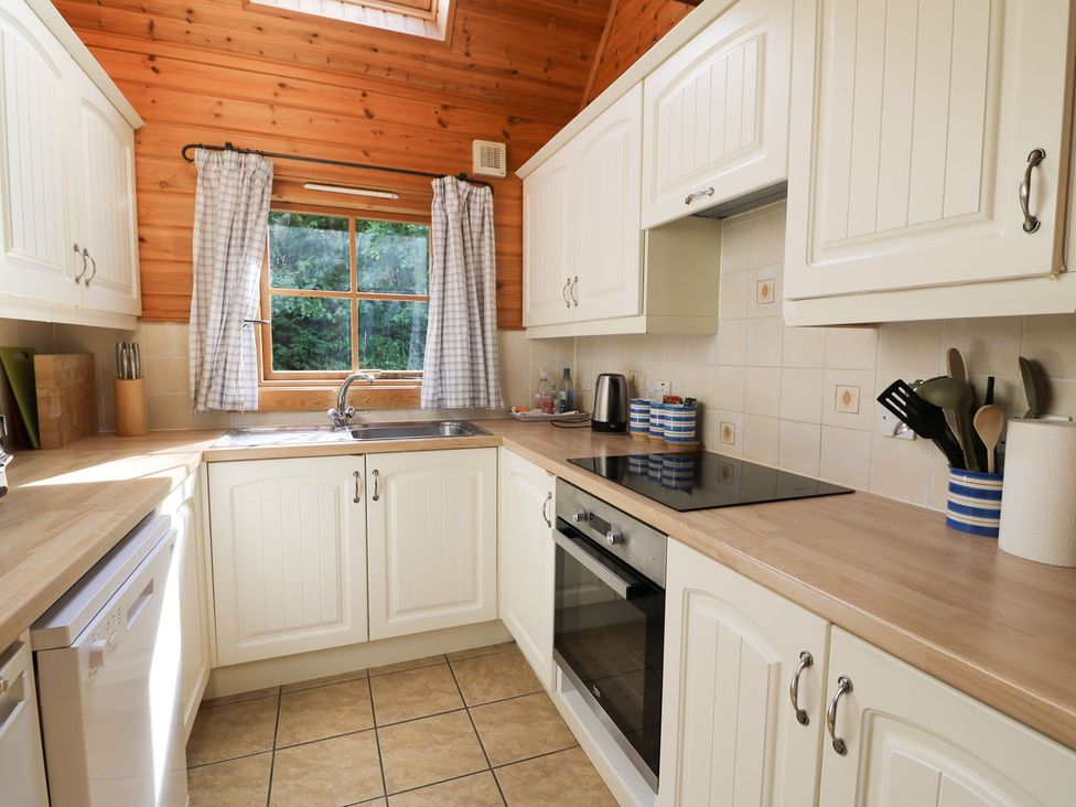 A kitchen with cabinets and a window at Pen Y Clawdd near Beggar's Bush near Presteigne