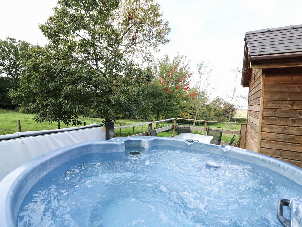 An outdoor area with a hot tub and seating at Pen Y Clawdd Beggar's Bush near Presteigne