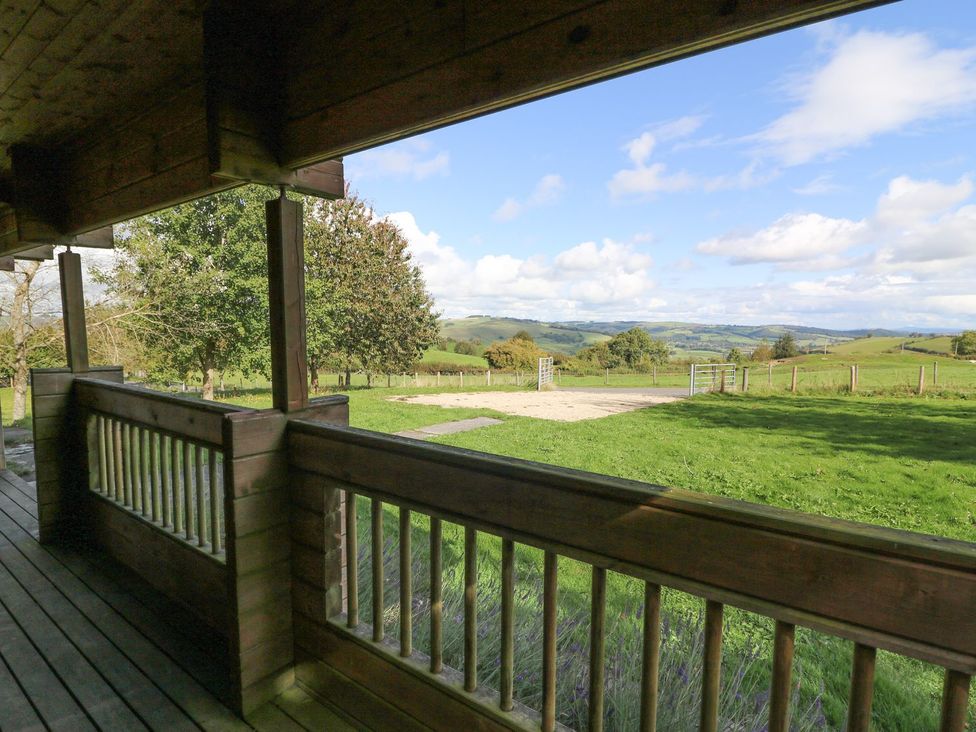 A view from a wooden deck overlooking hills and trees at Pen Y Clawdd in Beggar's Bush near Presteigne