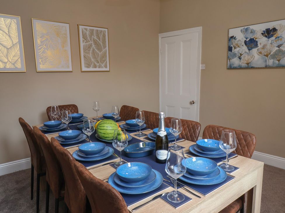 A dining room with a table set for a meal at Crescent Bay House