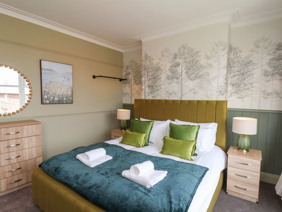 A bedroom with a bed and bedside tables at Crescent Bay House