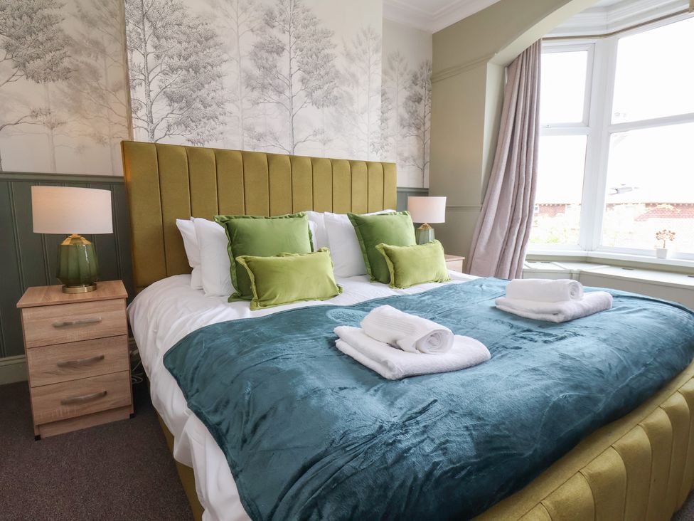 A bedroom with a bed and bedside lamp at Crescent Bay House