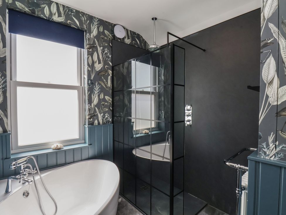 A bathroom with a bathtub and shower at Crescent Bay House