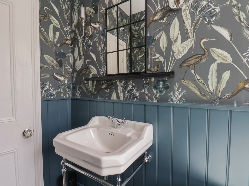 A bathroom with a sink and mirror at Crescent Bay House