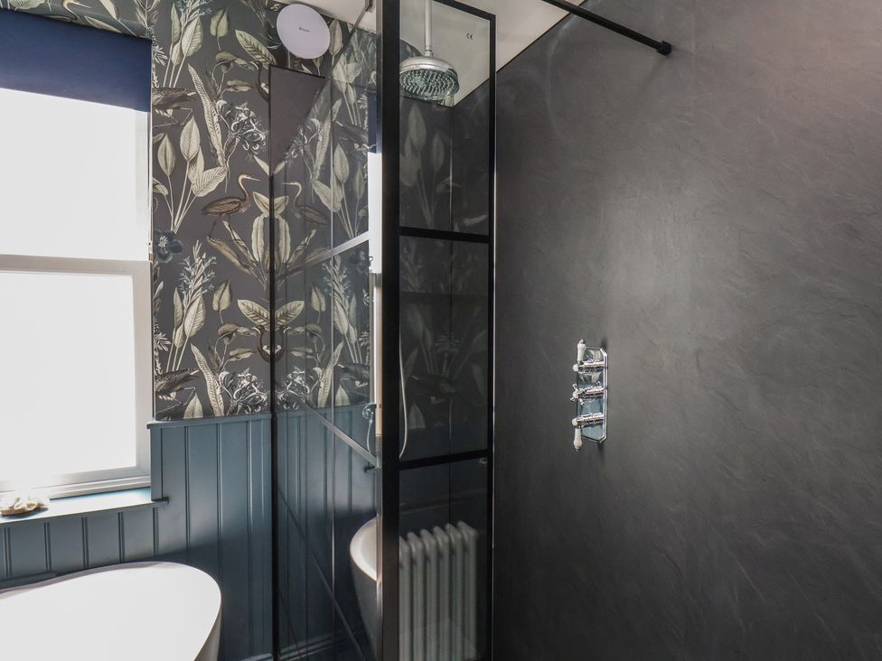 A bathroom with a shower and bathtub at Crescent Bay House