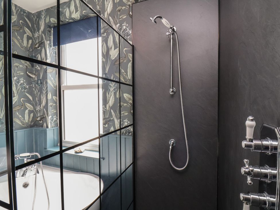 A bathroom with a shower and bathtub at Crescent Bay House