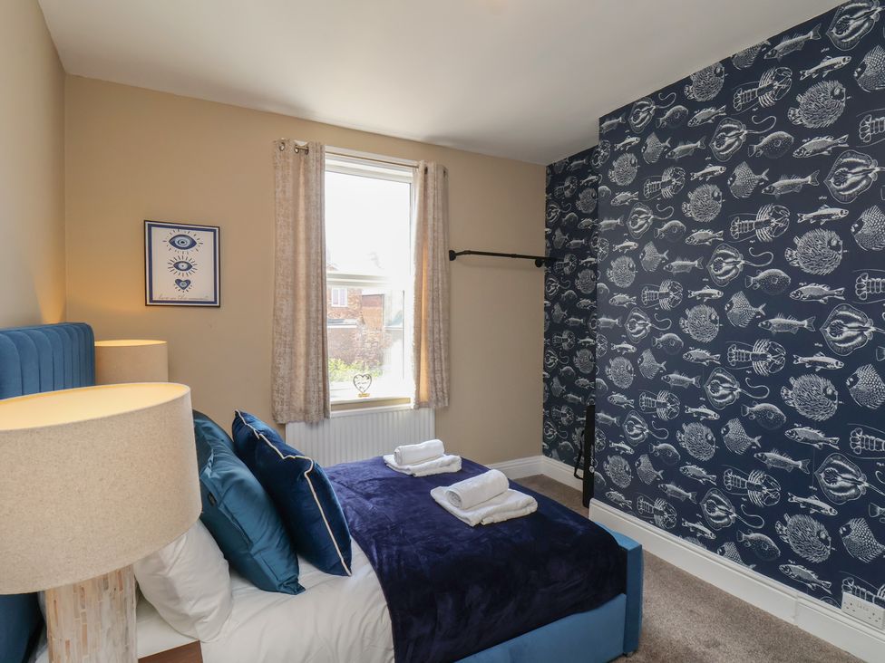 A bedroom with a bed and decorative lamp at Crescent Bay House