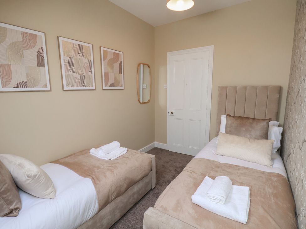 A bedroom with twin beds and wall art at Crescent Bay House